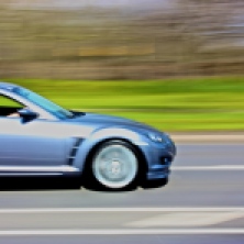 View of the natural background of the grass split by the speeding car using 'panning'